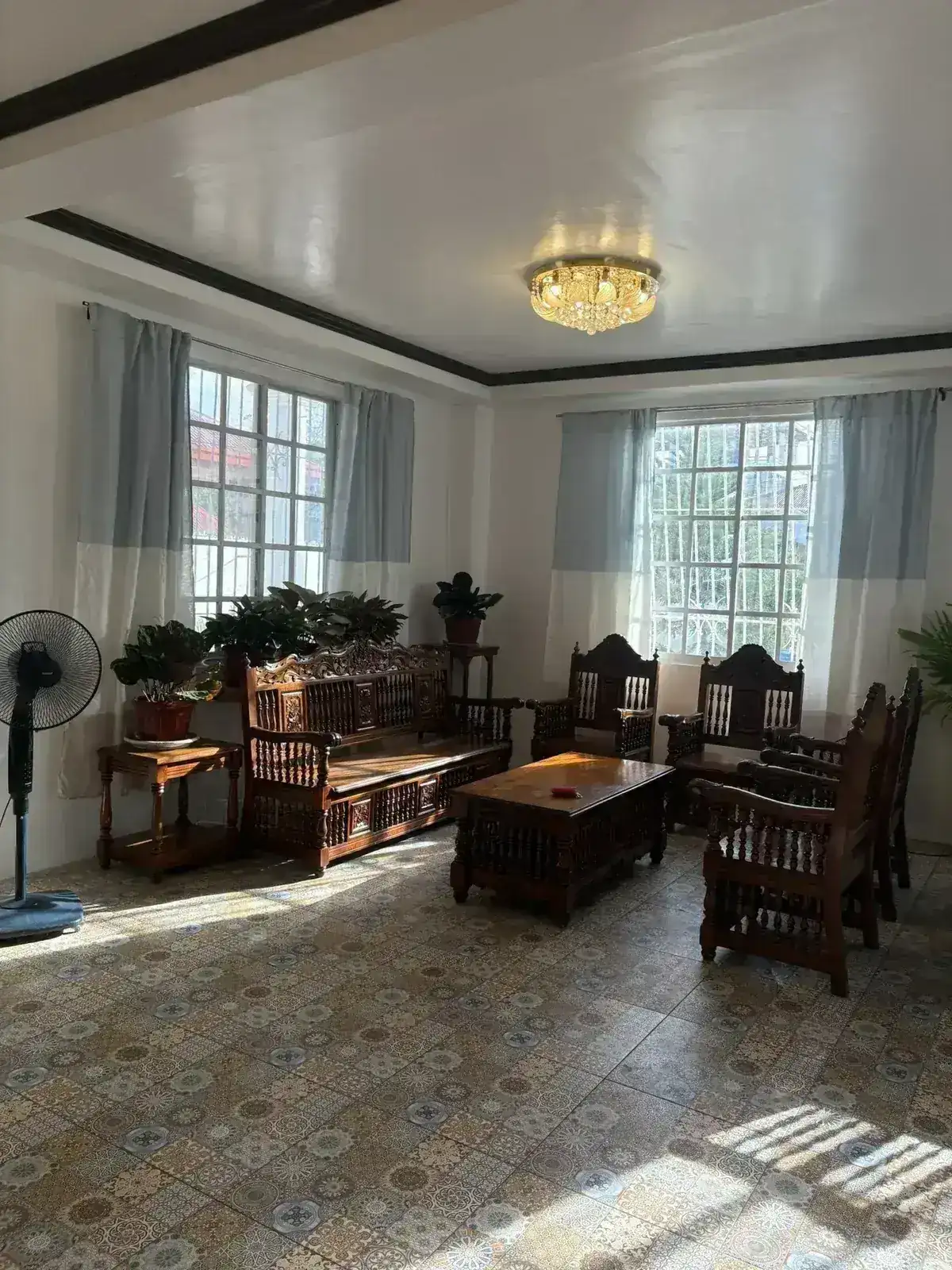 Sunlit living room with carved narra furniture